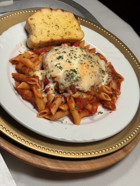 Chicken parmesan over pasta with marinara and melted cheese
