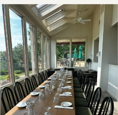 The sunroom set with a long table for a private event